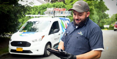 A technician reviewing a clipboard in front of a truck.